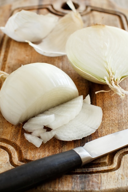 Cipolla bianca cruda fresca affettata sulla scheda di cottura