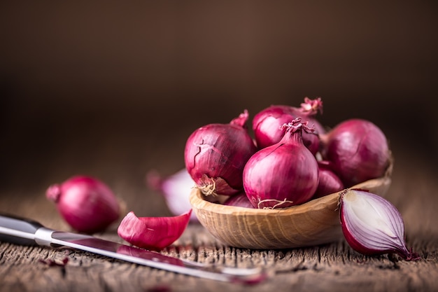 Cipolla. Cipolle rosse su tavola di legno di quercia molto vecchia. Messa a fuoco selettiva.