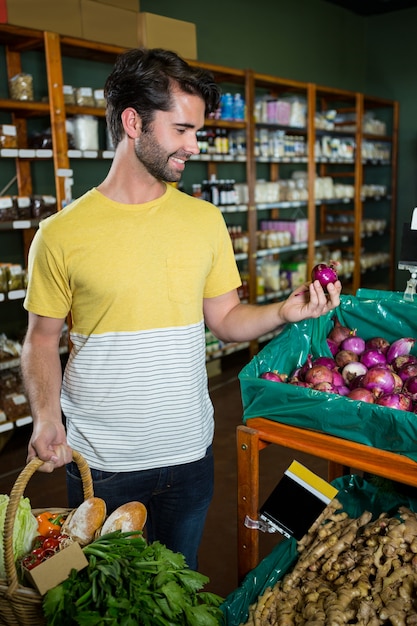 Cipolla d'acquisto dell'uomo in supermercato