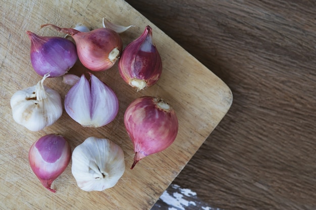 Cipolla e aglio per cucinare su sfondo di legno vecchio