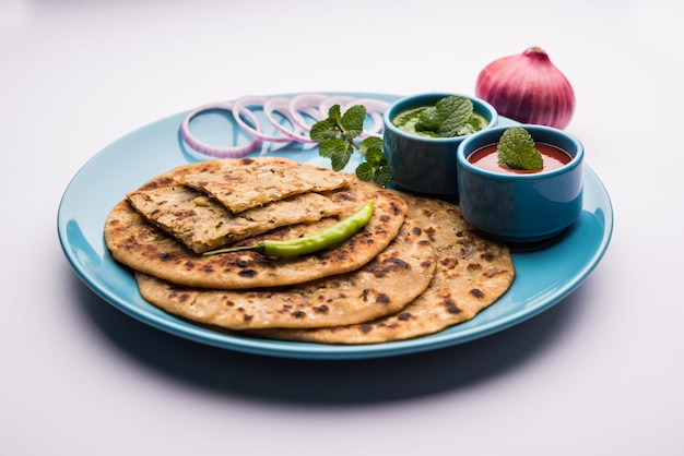 Cipolla Parotha o Pyaj parantha o kanda paratha servita con ketchup e chutney verde.