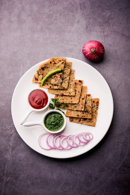 Cipolla Parotha o Pyaj parantha o kanda paratha servita con ketchup e chutney verde.