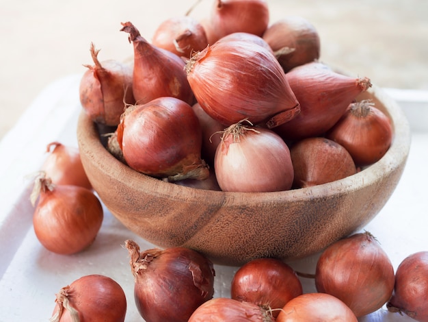 Cipolla rossa cruda in ciotola di legno sulla tavola di legno