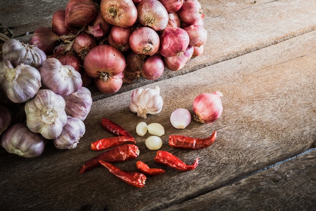 Cipolle, aglio e peperoncino secco sul tavolo di legno