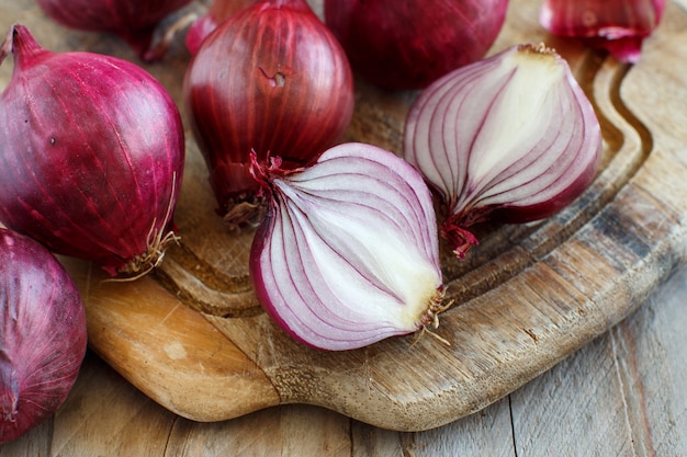 Cipolle rosse su una tavola di legno da vicino