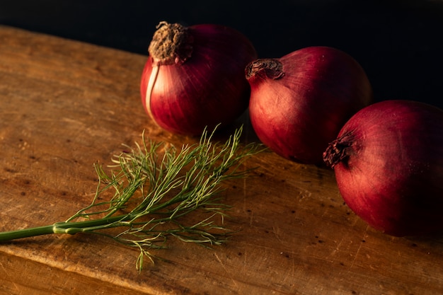 Cipolle su una tavola di legno con luce di windows