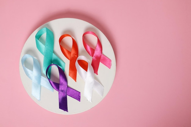 Circolo con nastri colorati di campagne di prevenzione delle malattie su uno sfondo rosa Giornata mondiale del cancro