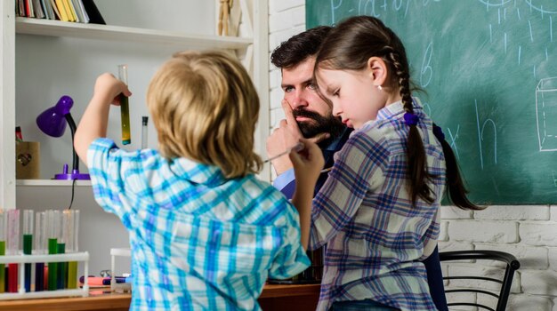 Circolo scolastico. Esperimento di chimica scolastica. Spiegare la chimica al bambino. Affascinante reazione chimica. Insegnante e alunni con provette in aula. Classi scolastiche interessanti. Educazione scolastica.