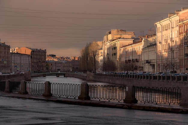 Città con edifici residenziali nel quartiere storico ponti fluviali al tramonto San Pietroburgo Russia