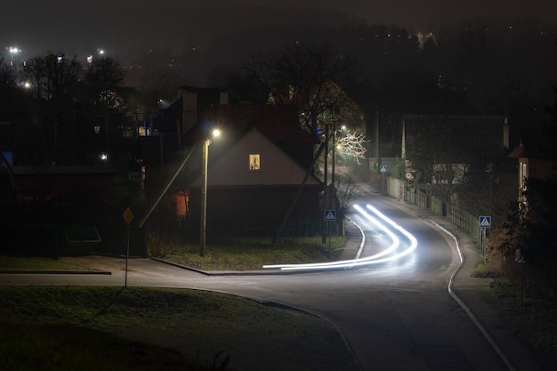 Città di notte Le scie di luce sulla strada Foto a bassa velocità dell'otturatore Un lungo ponte sul fiume conduce alla grande città Una trafficata superstrada nel centro del paese