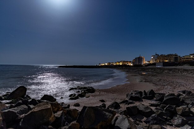 Città di Pomorie con luci e hotel sullo sfondo del cielo notturno e del Mar Nero in Bulgaria