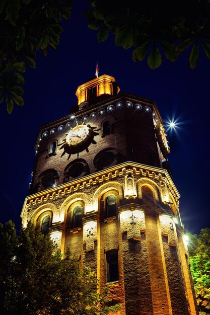 Città europea con la torre dell'orologio nelle luci della notte