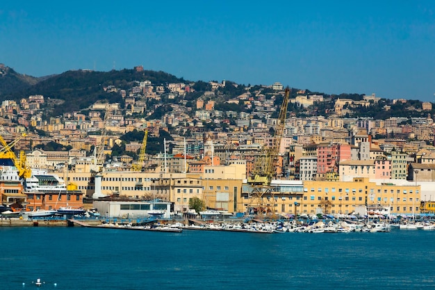 Città marittima in Italia belle case colorate lungo la costa gru portuali e yacht