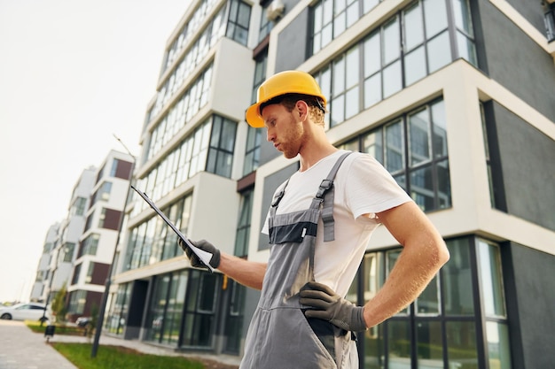 Città moderna Giovane che lavora in uniforme alla costruzione durante il giorno