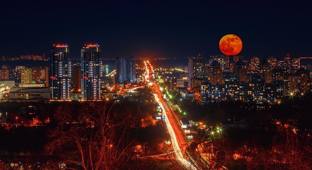 Città notturna con luna piena rossa
