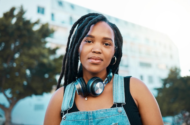 Città urbana e cuffie ritratto di donna nera in urbano gen z moda viaggio all'aperto o stile di vita giovanile Giovane ragazza africana alla moda o faccia da studente con tecnologia per lo streaming audio 5g in estate