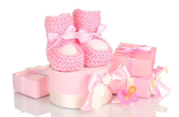 Ciuccio e regali rosa degli stivali del bambino isolati su bianco