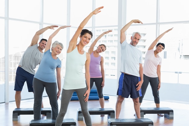 Classe che allunga le mani nella classe di yoga