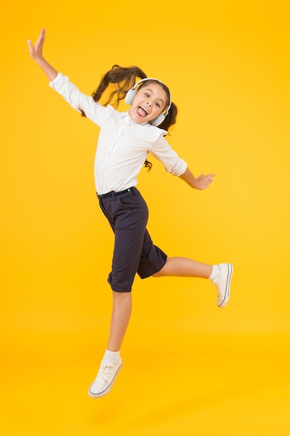 Classe di ballo Ballerino piccolo che si muove sulla musica su sfondo giallo Il bambino si diverte a ballare con la musica moderna Bambino energico che balla con piacere Imparare nella scuola di ballo