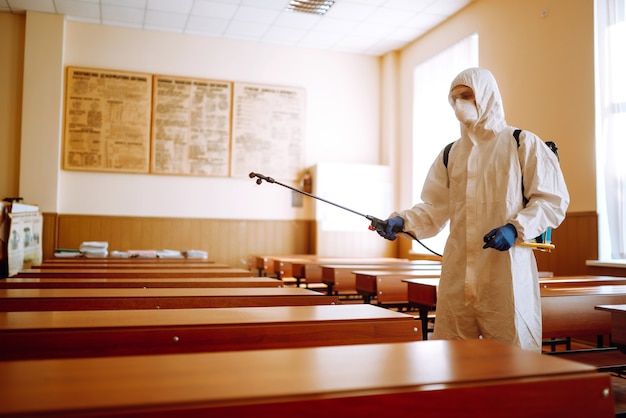 Classe scolastica di pulizia e disinfezione per prevenire COVID-19.