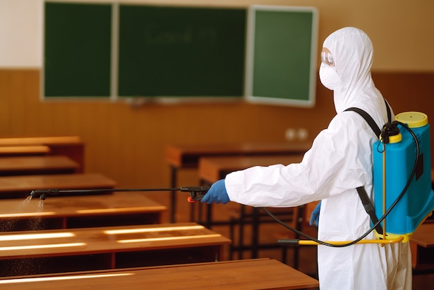 Classe scolastica di pulizia e disinfezione per prevenire COVID-19.