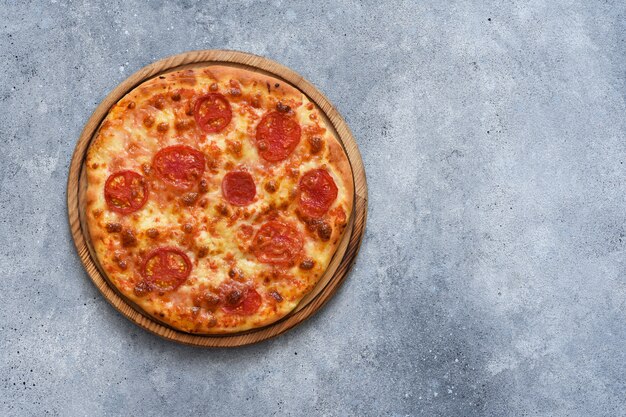 Classica pizza margarita con salsa di pomodoro e formaggio su una tavola di legno, vista dall'alto.