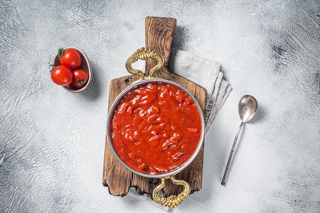 Classica salsa di pomodoro italiana al basilico per pasta e pizza in padella. Sfondo bianco. Vista dall'alto.