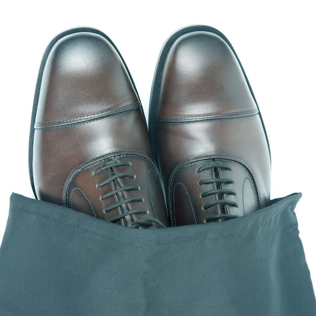 Classiche scarpe Oxford marroni da uomo in custodia protettiva nera su sfondo bianco