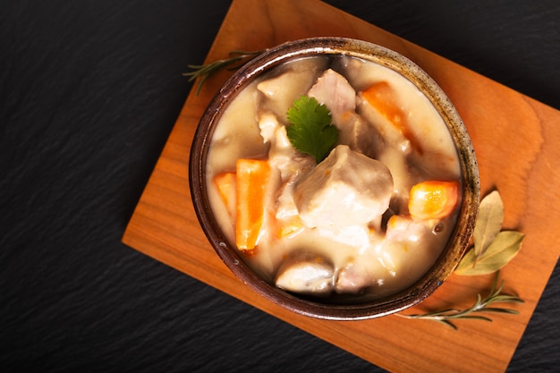 Classico concetto di cibo francese Blanquette de Veau o vitello in salsa di vino bianco in tazza di ceramica fatta a mano con lo spazio della copia