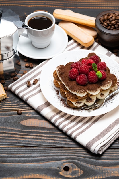 Classico dessert al tiramisù con lamponi e una tazzina di caffè espresso