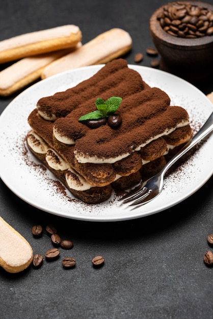 Classico dessert tiramisù su un piatto di ceramica