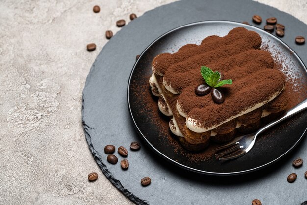 Classico dessert tiramisù su un piatto di ceramica