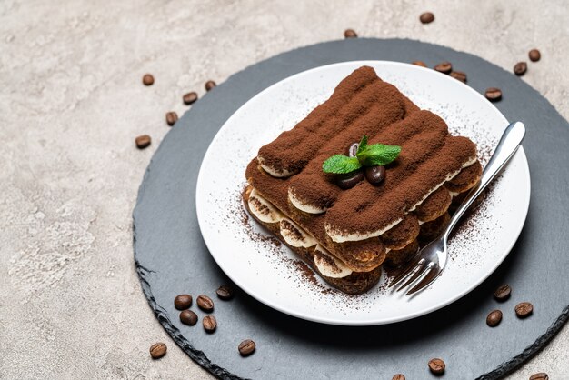 Classico dessert tiramisù su un piatto di ceramica