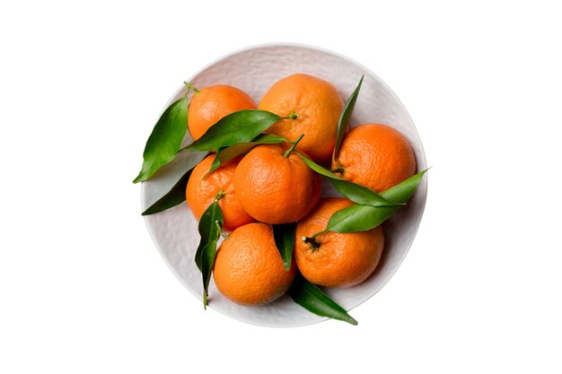 Clementine fresche tagliate e mandarini interi su piatto rotondo isolato su sfondo bianco Ingredienti per alimenti e bevande preparazione di un tema di alimentazione sana vista superiore con spazio per la copia