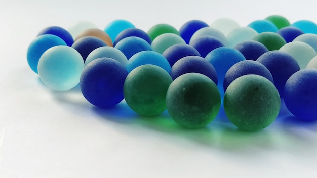 Clicker di gioco o palline di vetro colorate sparse su uno sfondo bianco retroilluminazione