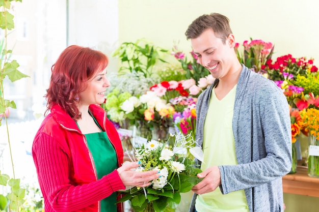 Cliente che compra le rose nel negozio di fiori