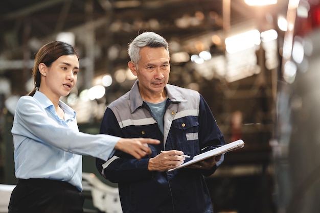 Cliente che effettua un controllo di ispezione su un lavoro di occupazione di riparazione del motore di un'auto presso l'officina della persona del tecnico del meccanico di servizio del garage al termine del trasporto di manutenzione automatica del veicolo dell'industria automobilistica