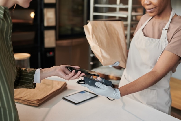 Cliente che paga online per il pane fresco nel panificio