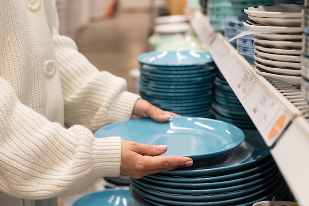 Cliente della donna che sceglie e acquista piatti di piatti di argilla blu