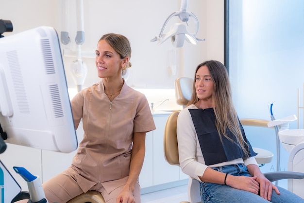 Cliente e dentista esaminano i risultati su uno schermo in una moderna clinica odontoiatrica