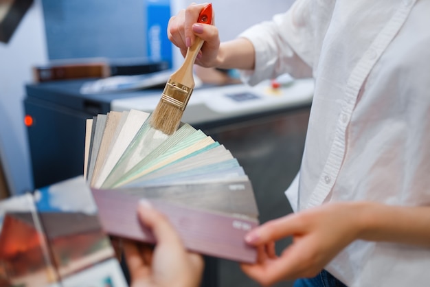 Cliente femminile che sceglie il colore nel negozio di ferramenta.