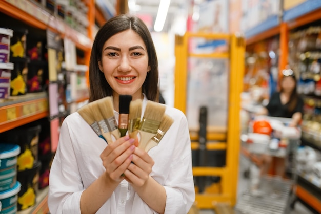 Cliente femminile che sceglie la spazzola nel negozio di ferramenta