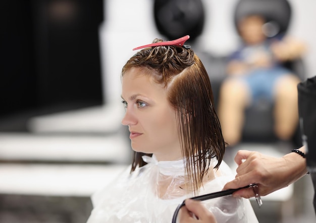 Cliente femminile con i capelli bagnati secchi dopo un intervento di bellezza maestro professionista dei capelli