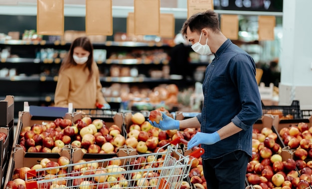 Clienti del supermercato in piedi vicino al bancone con le mele