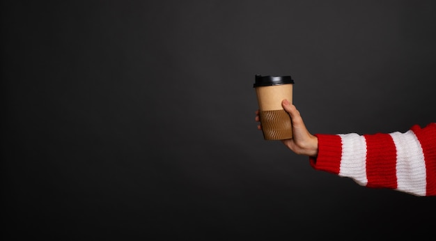 Close up banner foto di giovane braccio femminile con tazza di caffè di carta con posto per logo e pubblicità
