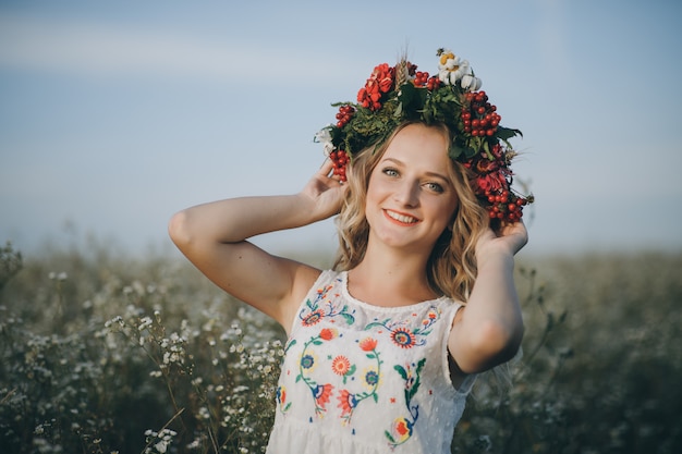 Close-up, Beauty Ritratto di una ragazza bionda con gli occhi azzurri con una corona di fiori in testa