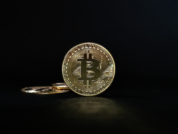 Close up bitcoin oro su sfondo nero con il fuoco selettivo