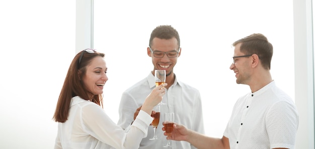 Close up.business team tintinnano bicchieri di vino. il concetto di una startup di successo