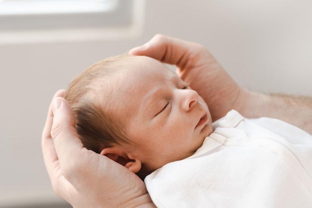 Close up caucasico peloso brunet carino neonato sleepingone o due settimane bambino in handsunre maschio