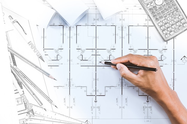 Close-up del piano di disegno a mano di ingegnere persona su stampa blu con strumento architetto a scrivania.